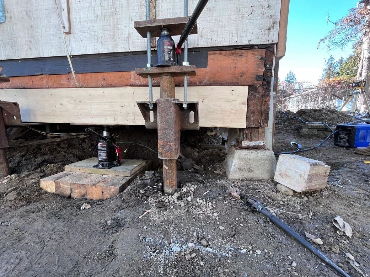 Underpinning piles used to stabilize and lift a cabin by 10 inches, raising it above the designated flood level.