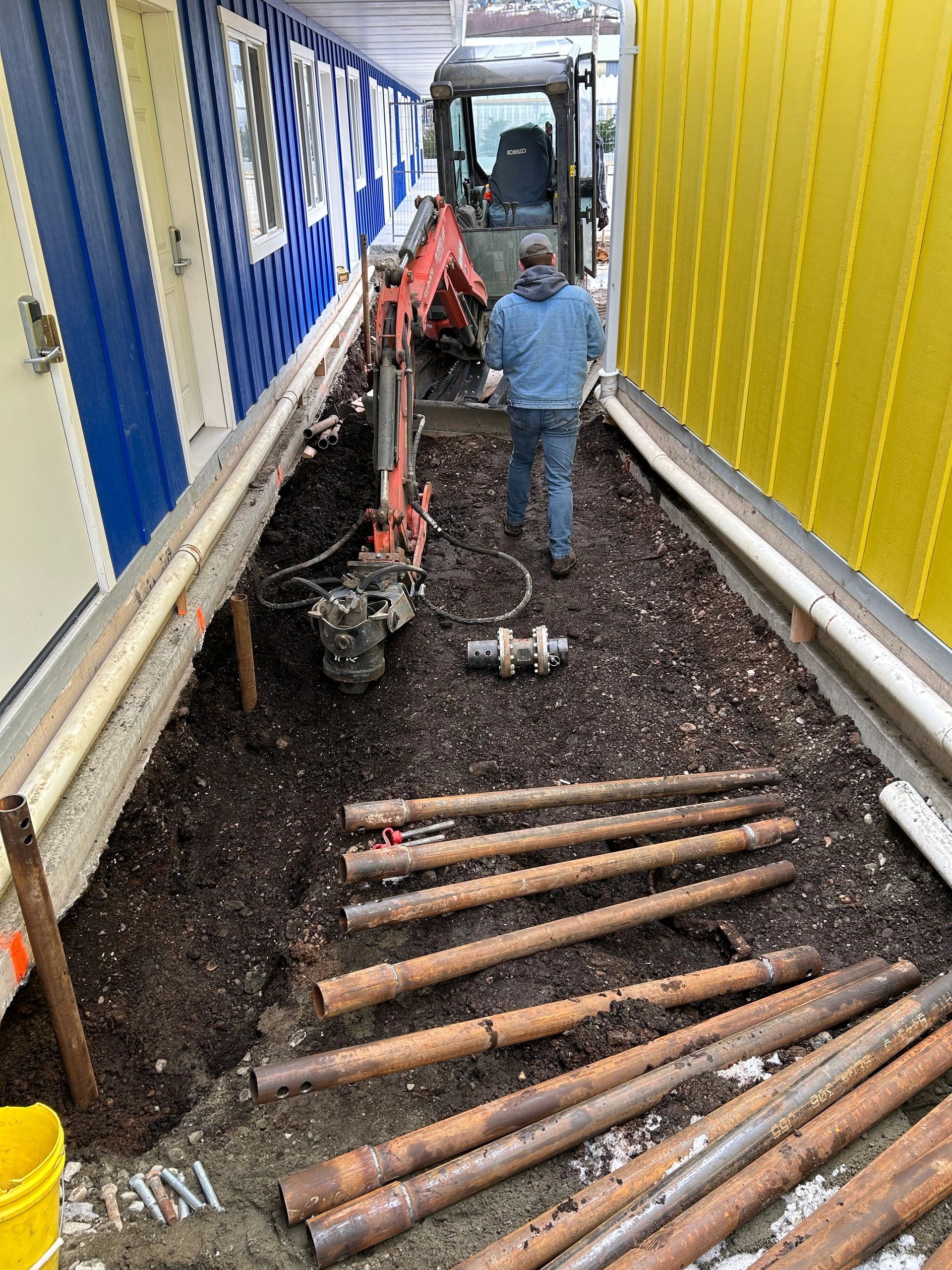 Helical piles installed in a tight access location to stabilize the structure and lift it by 3.5 inches, bringing it back into compliance